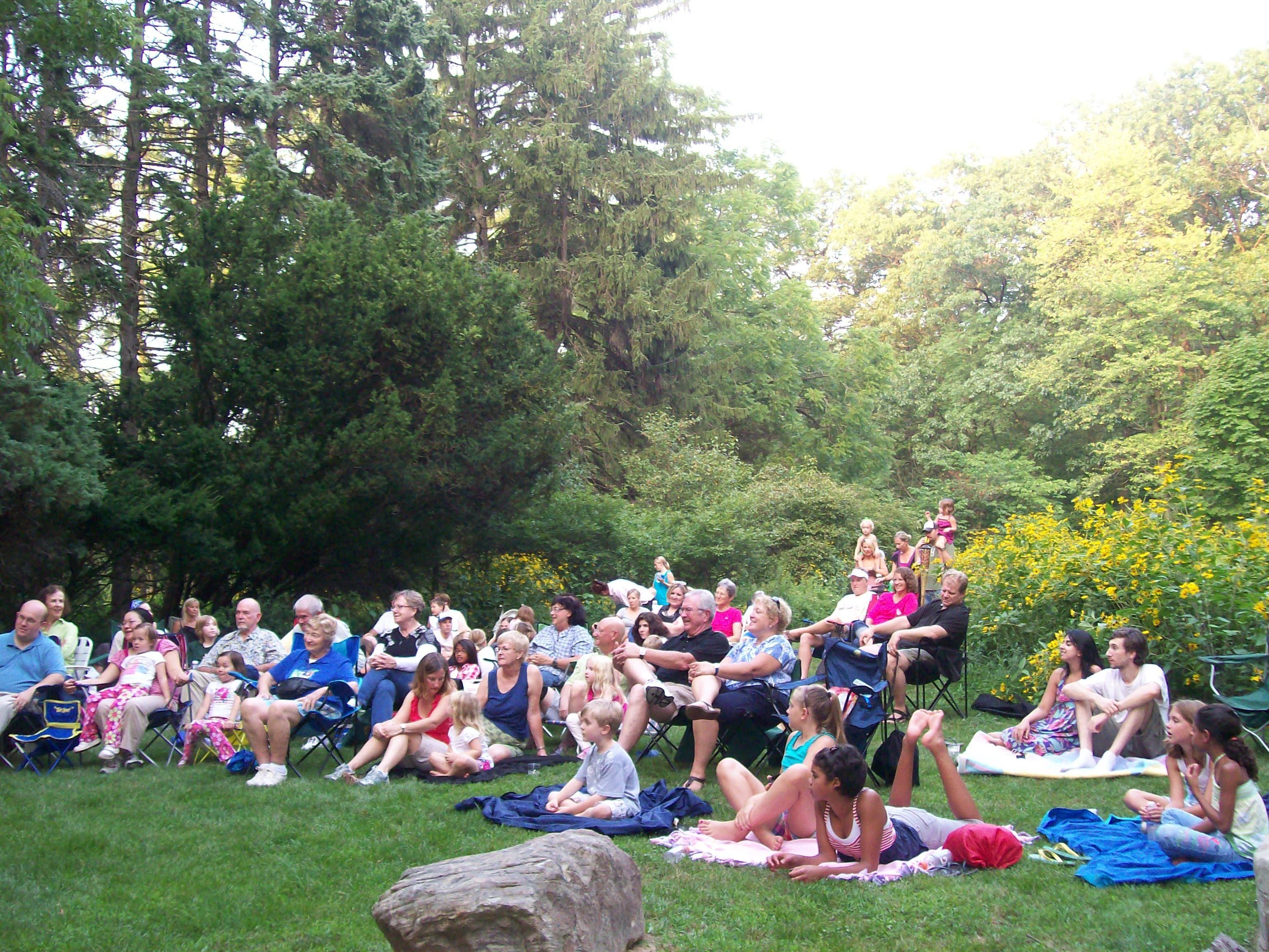 People gathered outdoors on a grassy area enjoying a sunny day.