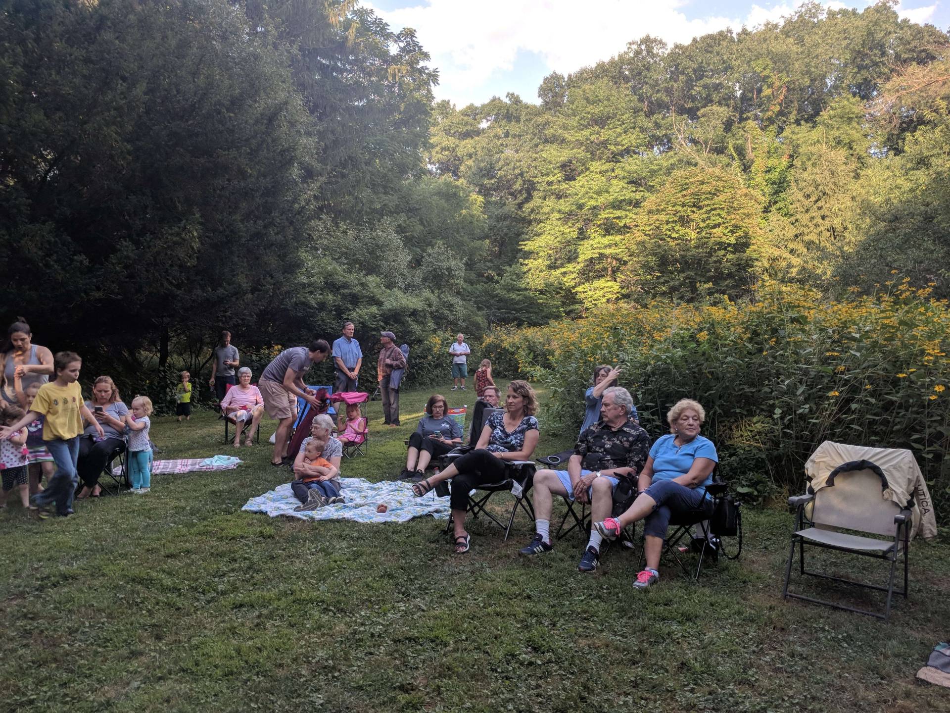 Group of people enjoying a picnic in a lush green park.
