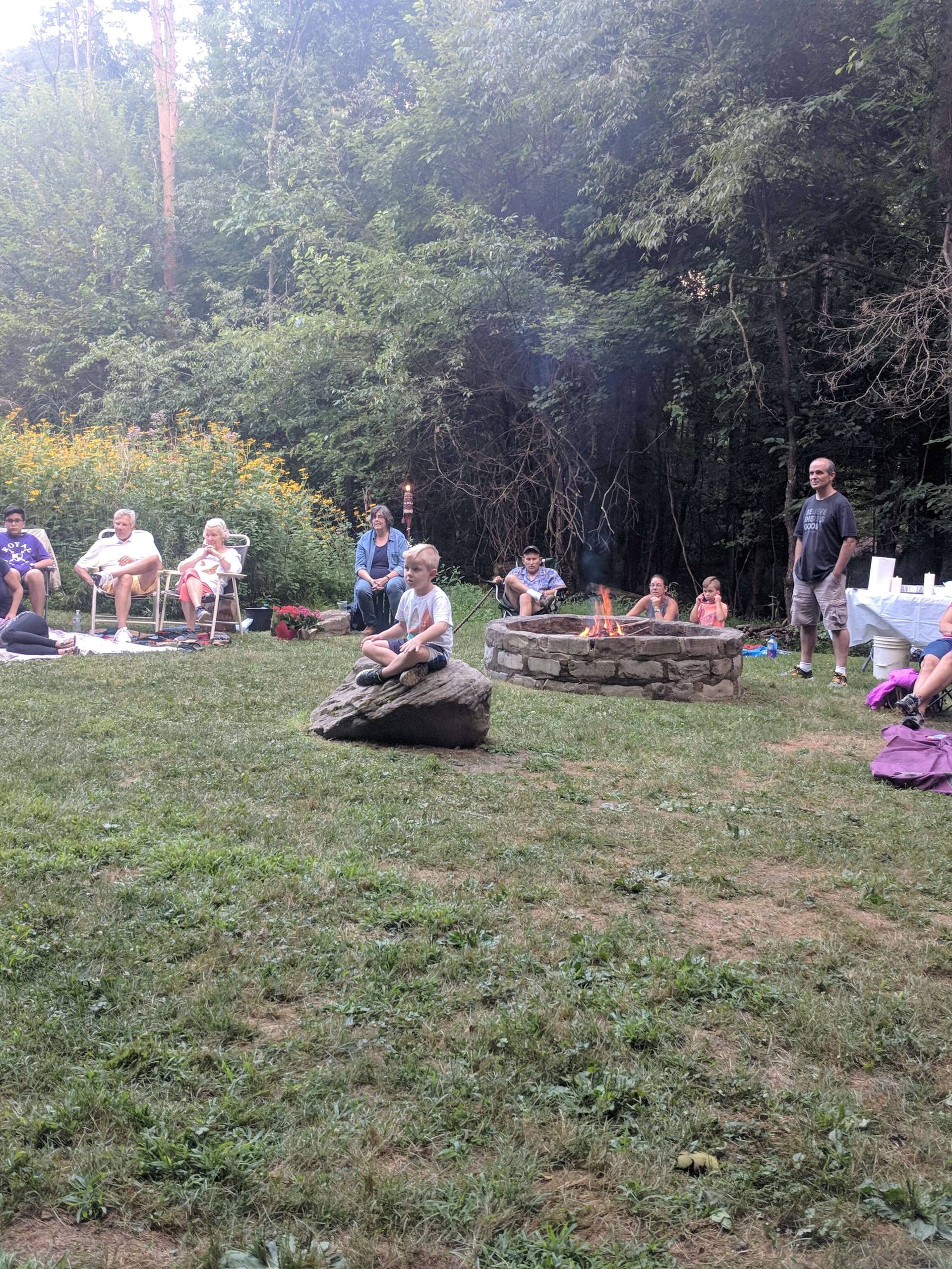 People sitting outdoors in a circle during a group activity.